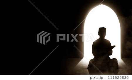Silhouette of a Muslim man sitting and reading the koran with bright light Silhouette of a Muslim man sitting and reading the koran with bright light 111626886