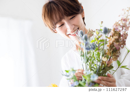花を花瓶に生ける女性 111627297