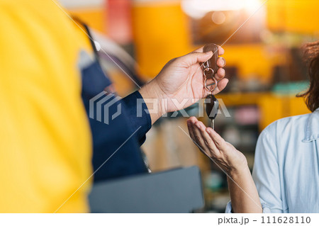 Mechanic car dealer giving car key to customer for finished car service fix problem or auto sell deal Mechanic car dealer giving car key to customer for finished car service fix problem or auto sell deal 111628110