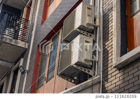 Air conditioner outdoor unit heat condenser coils fan cooling use R32 exchange gas liquid at Asian city building Air conditioner outdoor unit heat condenser coils fan cooling use R32 exchange gas liquid at Asian city building 111628209