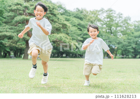 公園で追いかけっこする活発な子供達・兄弟・走る・短距離走 公園で追いかけっこする活発な子供達・兄弟・走る・短距離走 111628213