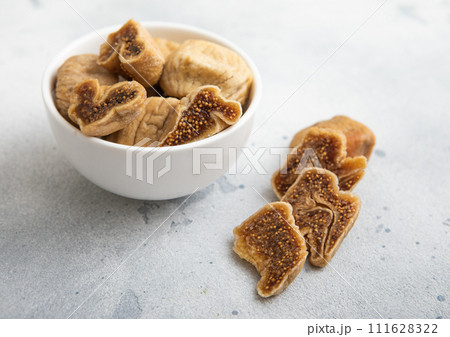 Dried sweet organic white figs in ceramic bowl on light background. 111628322