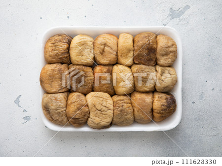 Tray with organic dried sweet figs on white kitchen background. Tray with organic dried sweet figs on white kitchen background. 111628330