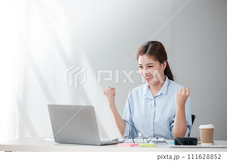 Cheerful Successful Asian Business woman using calculator and laptop for doing math finance on an office desk, tax, report, accounting, statistics, and analytical research concept Cheerful Successful Asian Business woman using calculator and laptop for doing math finance on an office desk, tax, report, accounting, statistics, and analytical research concept 111628852
