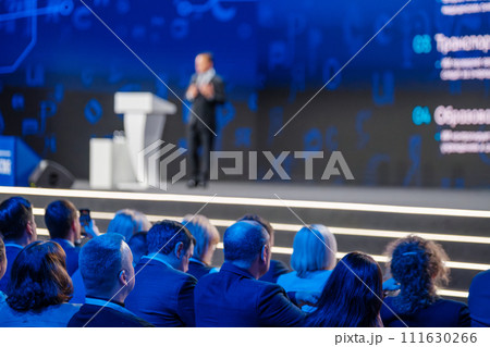 Focused audience at business conference with speaker on stage talking 111630266