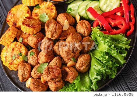 baked meatballs with vegetables and sauce on plate 111630909