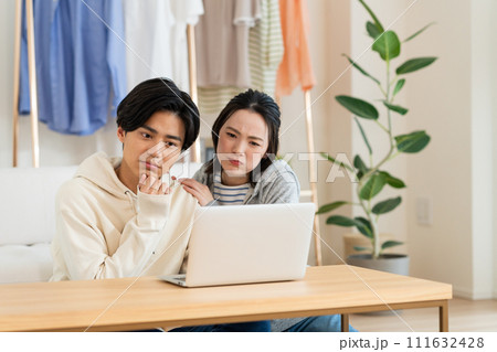 リビングでパソコンを見る若いカップル 111632428