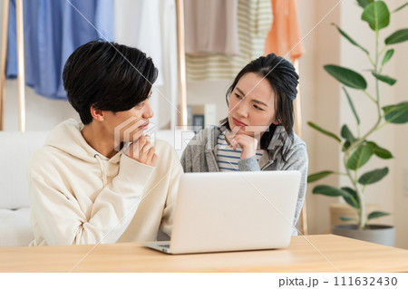 リビングでパソコンを見る若いカップル 111632430