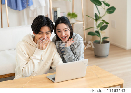 リビングでパソコンを見る若いカップル 111632434