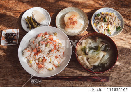 鮭とうすいえんどうの豆ご飯とお味噌汁と小鉢の家庭的な和食 鮭とうすいえんどうの豆ご飯とお味噌汁と小鉢の家庭的な和食 111633162
