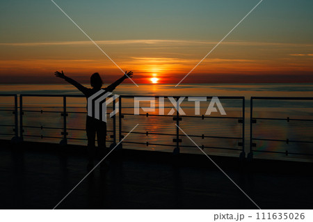 Girl silhouette in magical sunset over the Gulf of Finland, Baltic sea. Girl silhouette in magical sunset over the Gulf of Finland, Baltic sea. 111635026