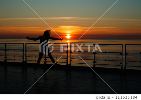 Girl silhouette in magical sunset over the Gulf of Finland, Baltic sea. 111635184