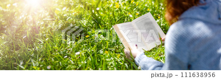 Young woman lying on the field and reading a book. Young woman lying on the field and reading a book. 111638956