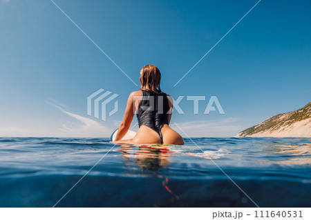 Attractive sexy surf girl on surfboard in blue ocean 111640531