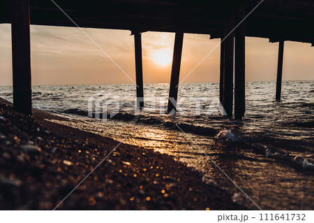 beautiful evening landscape on the sea. sunset of the setting sun. the sun disappeared behind the horizon of the sea. sea view through the pillars of the embankment.Turkey Mediterranean Sea 111641732