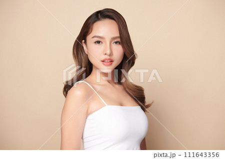 Beautiful young asian woman with clean fresh skin on beige background, Face care, Facial treatment, Cosmetology, beauty and spa, Asian women portrait. Beautiful young asian woman with clean fresh skin on beige background, Face care, Facial treatment, Cosmetology, beauty and spa, Asian women portrait. 111643356