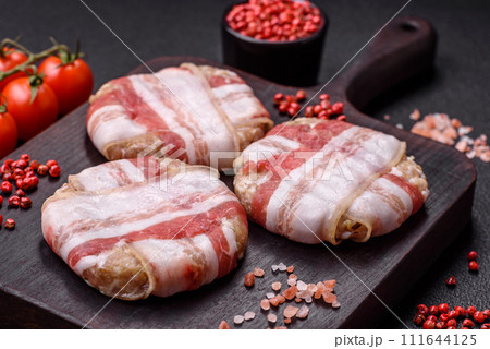 Round minced chicken or pork cutlet wrapped in bacon with salt, spices and herbs 111644125