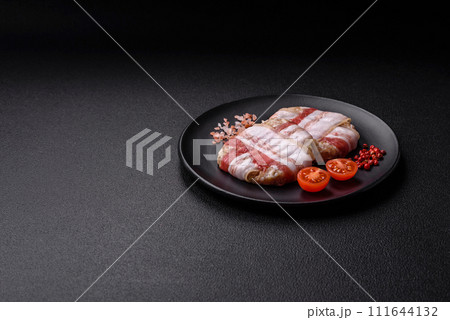 Round minced chicken or pork cutlet wrapped in bacon with salt, spices and herbs Round minced chicken or pork cutlet wrapped in bacon with salt, spices and herbs 111644132