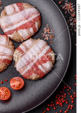 Round minced chicken or pork cutlet wrapped in bacon with salt, spices and herbs Round minced chicken or pork cutlet wrapped in bacon with salt, spices and herbs 111644167