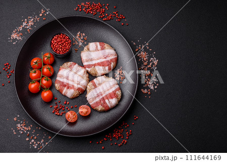 Round minced chicken or pork cutlet wrapped in bacon with salt, spices and herbs 111644169