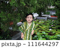 lovely boy dressed up in Japanese costume in water lily garden  111644297