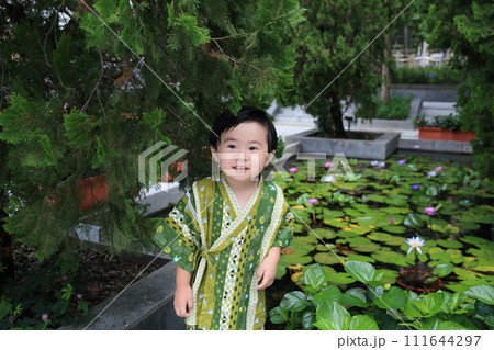 lovely boy dressed up in Japanese costume in water lily garden lovely boy dressed up in Japanese costume in water lily garden 111644297