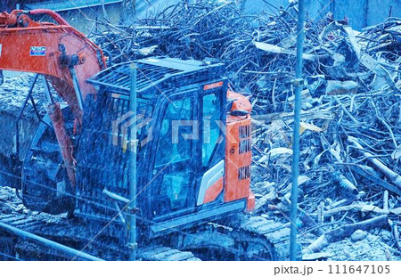 雪の中の重機とガレキ 雪の中の重機とガレキ 111647105