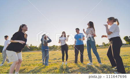 Funny jolly friends dancing in the city meadow in the evening. Funny jolly friends dancing in the city meadow in the evening. 111647696