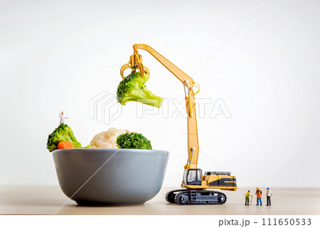 Miniature people making salad. Cooking concept Miniature people making salad. Cooking concept 111650533