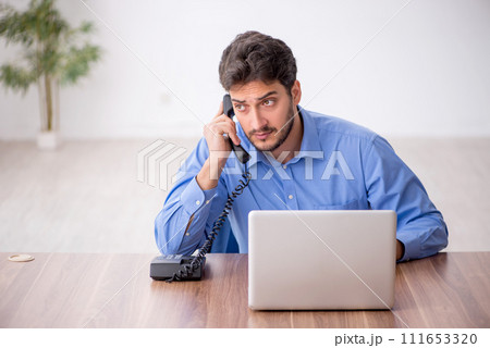 Young male employee working in the office Young male employee working in the office 111653320