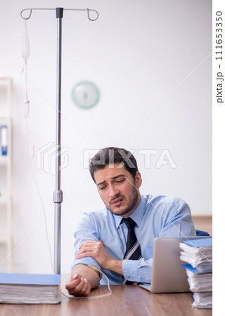 Young male employee suffering at workplace Young male employee suffering at workplace 111653350