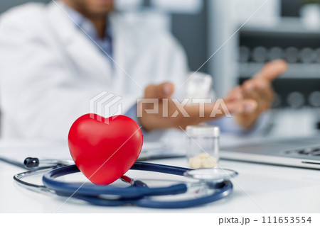Stethoscope and red heart on wooden table. Cardiology concept Stethoscope and red heart on wooden table. Cardiology concept 111653554