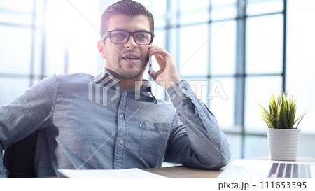 A male office worker is talking on the phone A male office worker is talking on the phone 111653595