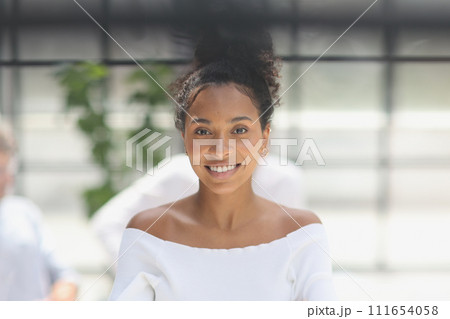 a business woman smiling inside office building a business woman smiling inside office building 111654058