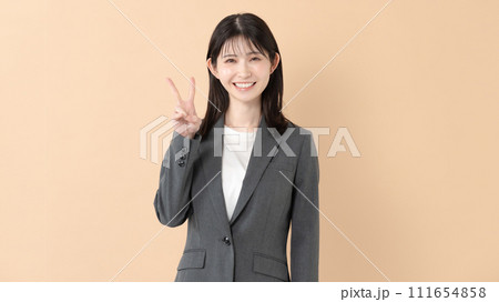 ピースサインをするスーツ姿の女性 111654858
