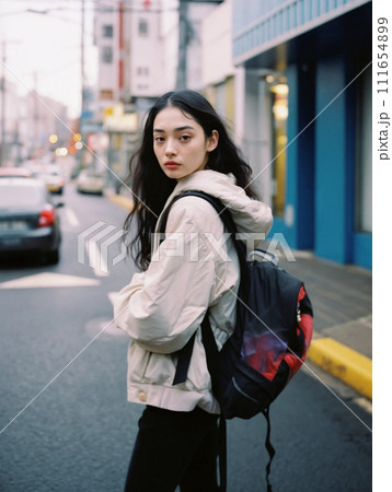 リュックを背負って街を歩く女性 111654899