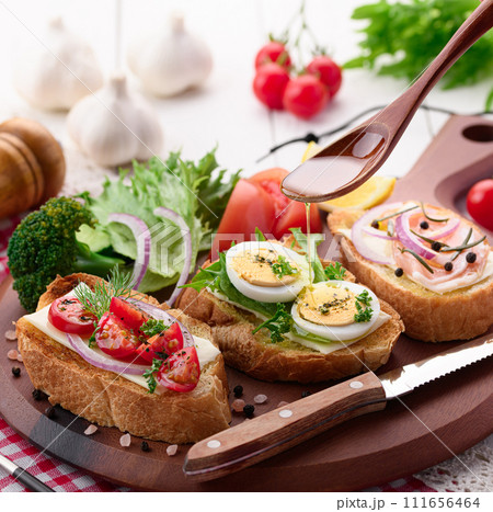 ブルスケッタにオリーブオイルをかける 111656464