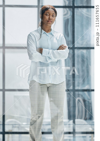 happy young african american young woman sitting in her chair smiling 111657655