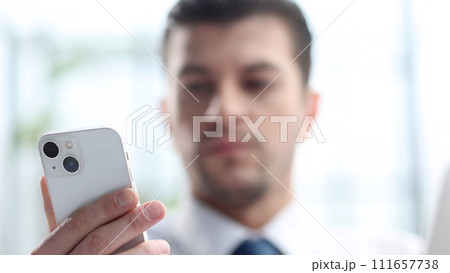 A male businessman uses a phone in close-up 111657738