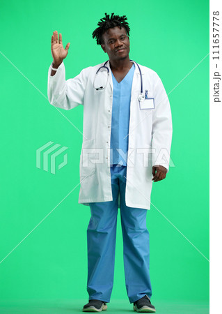 The doctor, in full height, on a green background, waving his hand 111657778