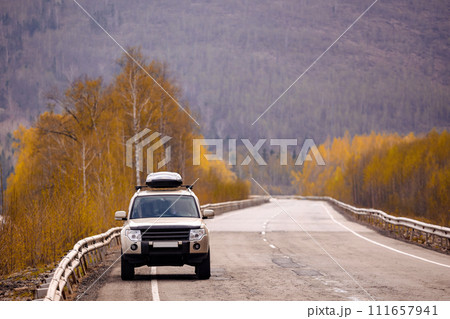 SUV on scenic autumn road in the forest 111657941