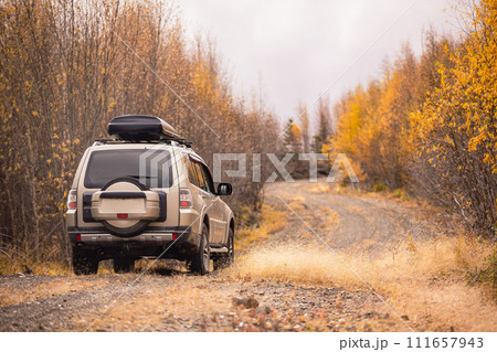 SUV on scenic autumn road in the forest 111657943