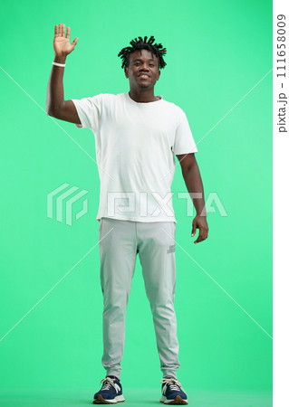 A man, full-length, on a green background, waving his hand A man, full-length, on a green background, waving his hand 111658009