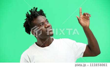 Man, close-up, on a green background, pointing up Man, close-up, on a green background, pointing up 111658061