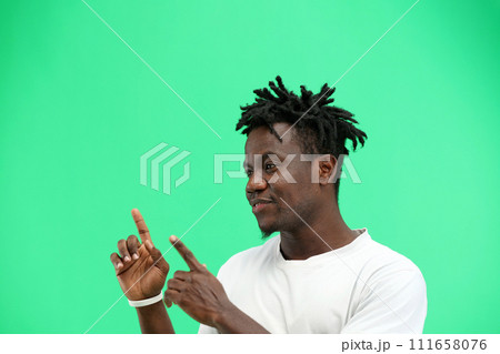 A man, close-up, on a green background, points to the side 111658076