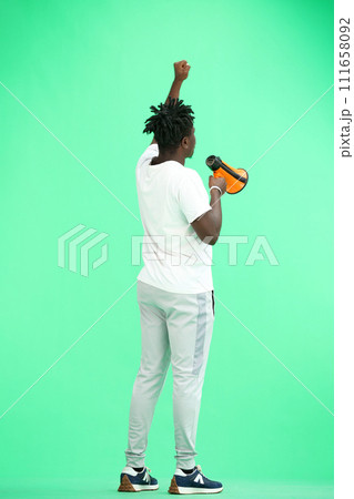 A man, full-length, on a green background, with a megaphone 111658092