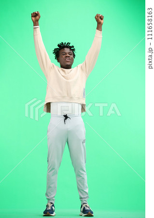 A man, full-length, on a green background, raised his hands up 111658163