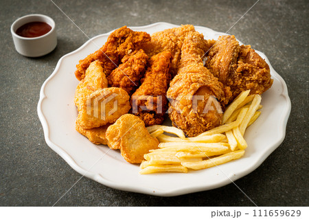 fried chicken with french fries and nuggets on plate fried chicken with french fries and nuggets on plate 111659629