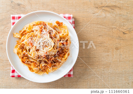 Homemade pasta fettuccine bolognese with cheese 111660361