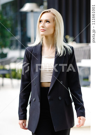 Business women style. Woman going to work walking on the street. Portrait of beautiful smiling female in stylish office clothes going on the street. Business women style. Woman going to work walking on the street. Portrait of beautiful smiling female in stylish office clothes going on the street. 111661001